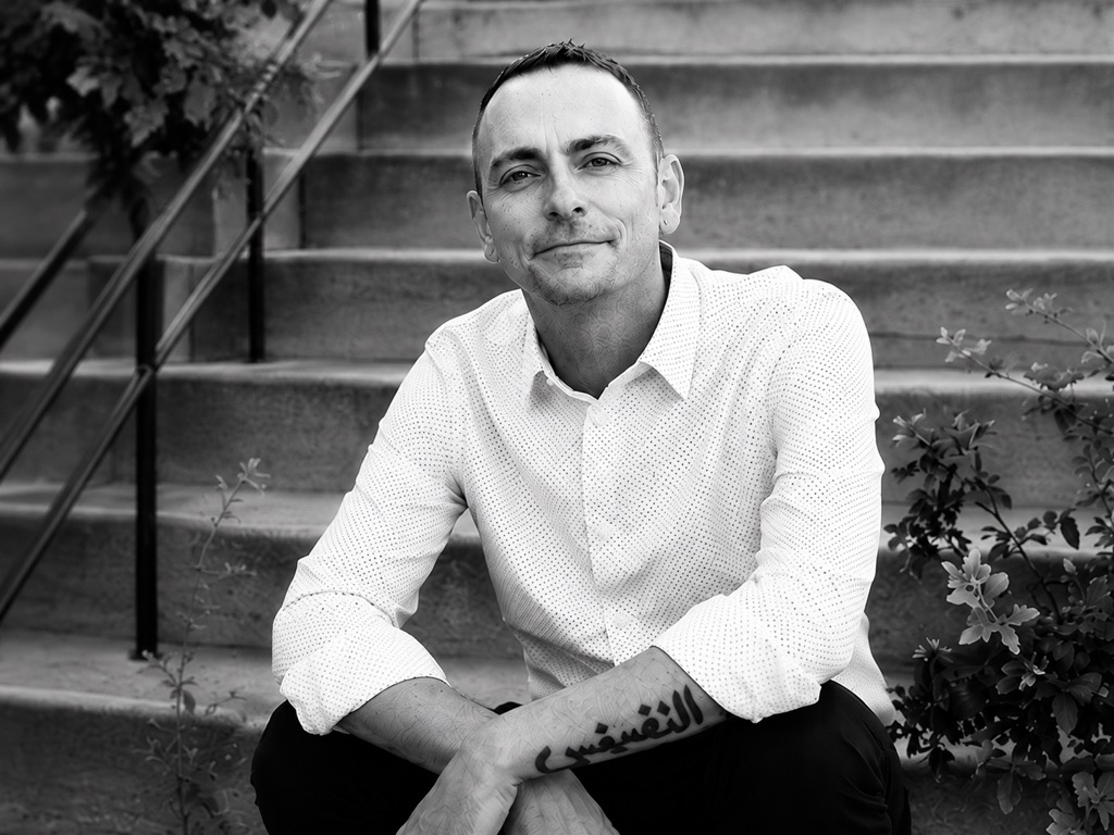 Patrik Strate seated outdoors on stone steps